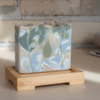 Marbled soap bar on a wooden stand with a rustic background